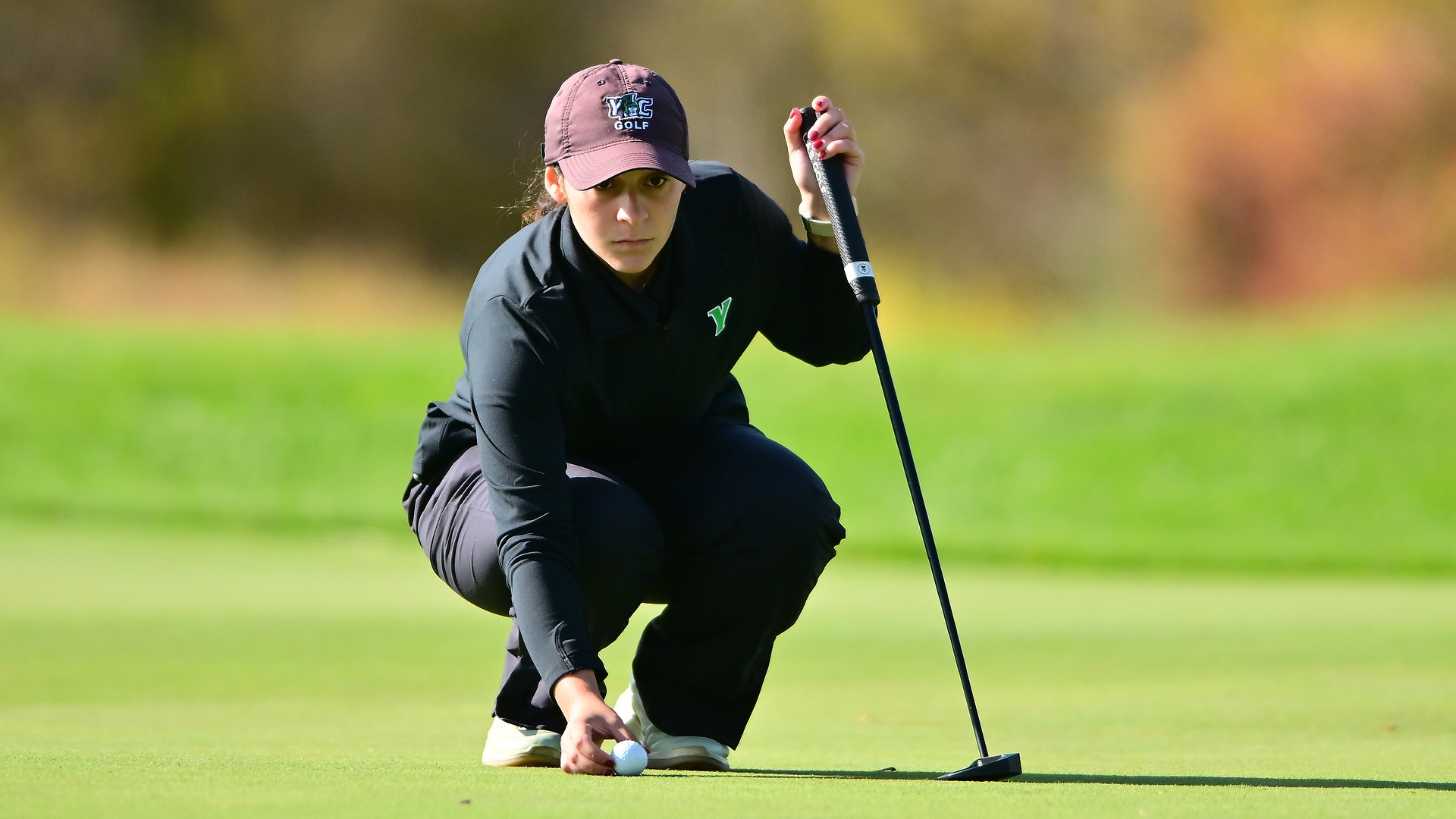 female golfer places ball on ground