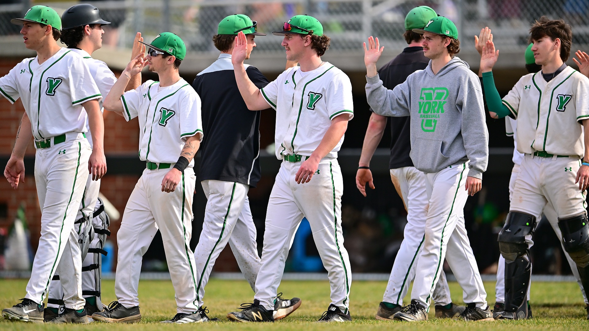 members of baseball team high five after a victory