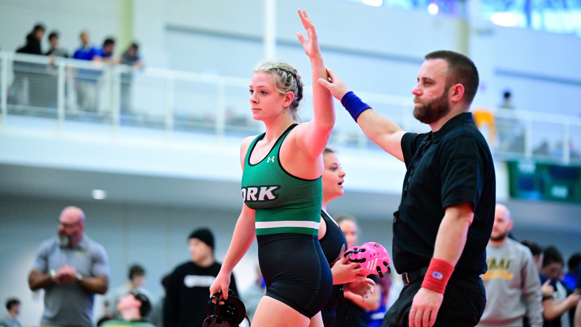 female wrestler has hand raised after a victory at New Standard Invitational