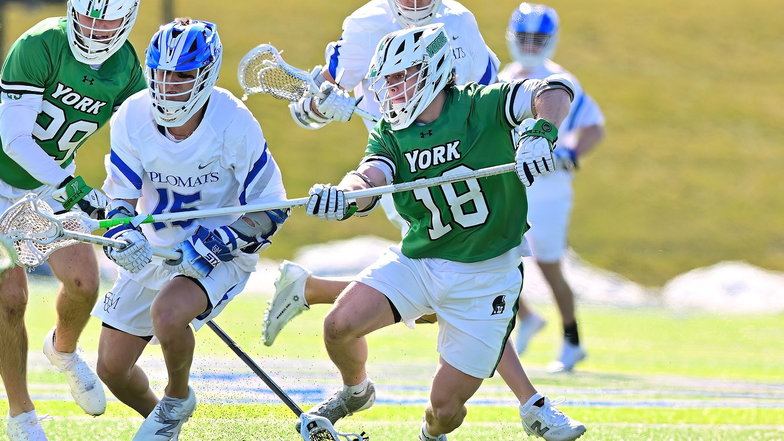 male lacrosse player stick checks opponent