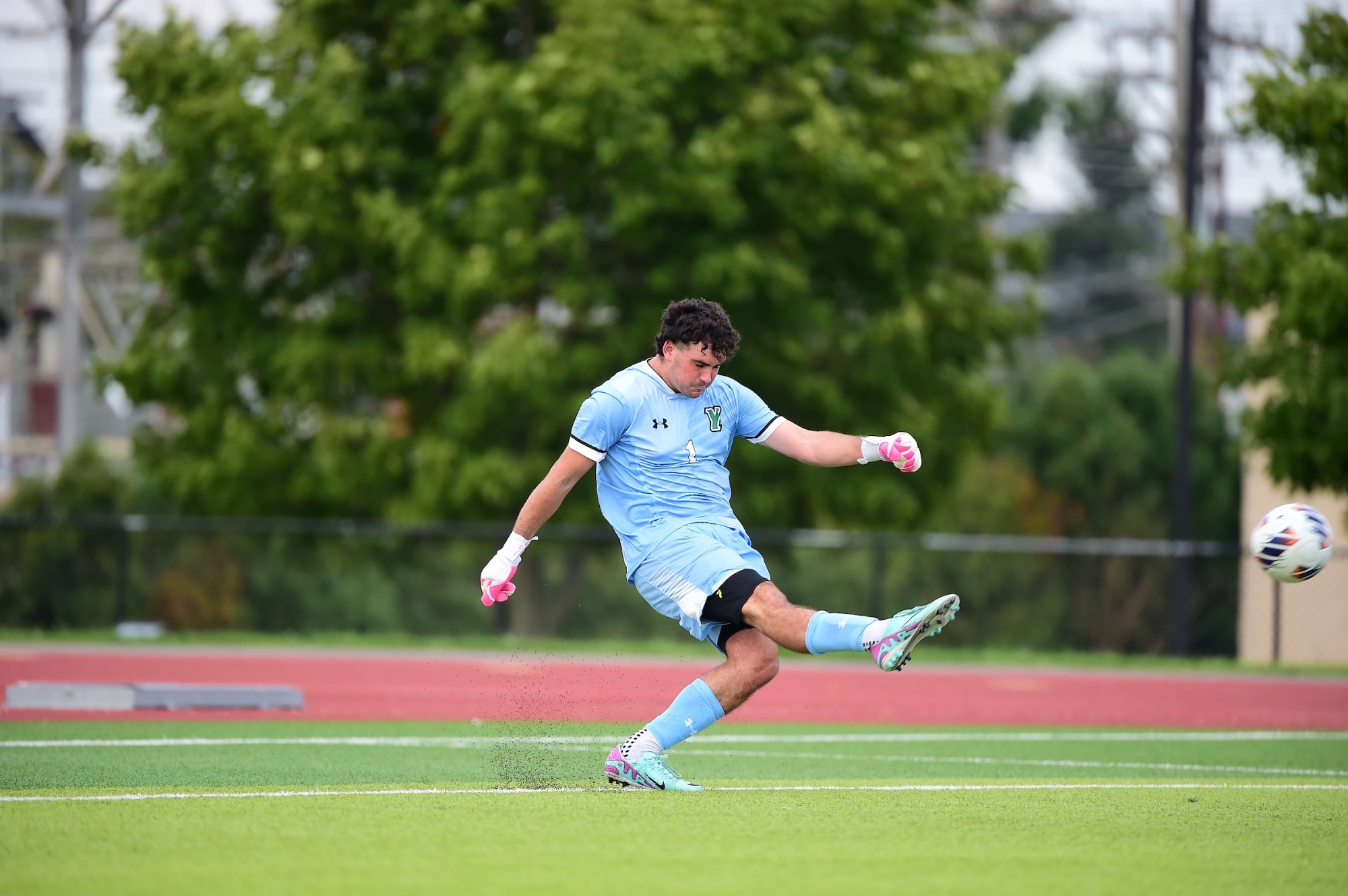 Male goalie punting soccer ball
