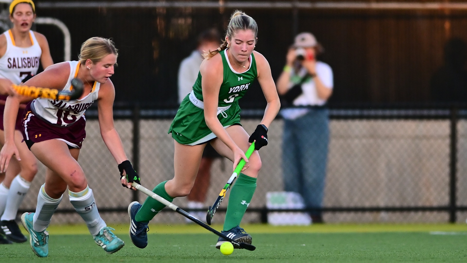 Two field hockey players compete for possession of the ball