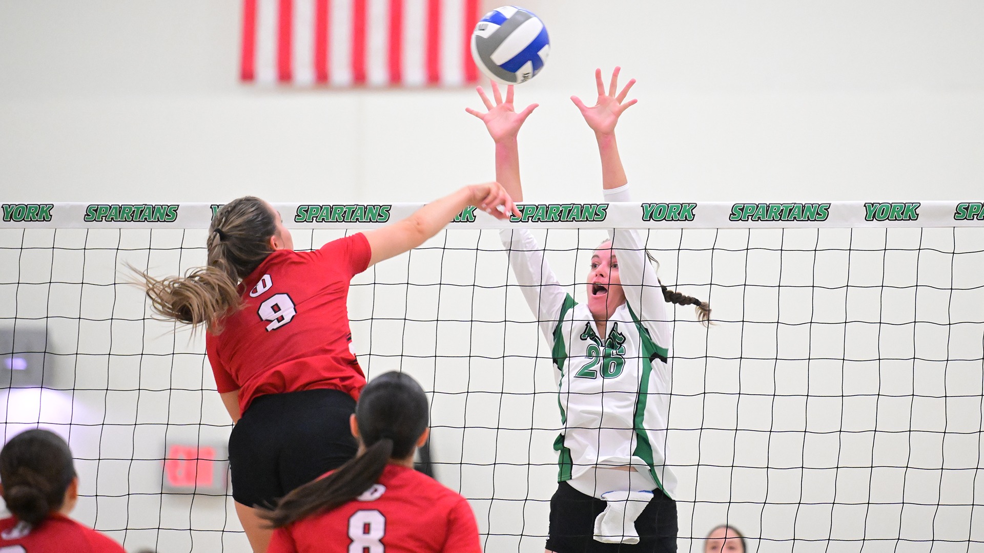 female volleyball player goes up for a block attempt