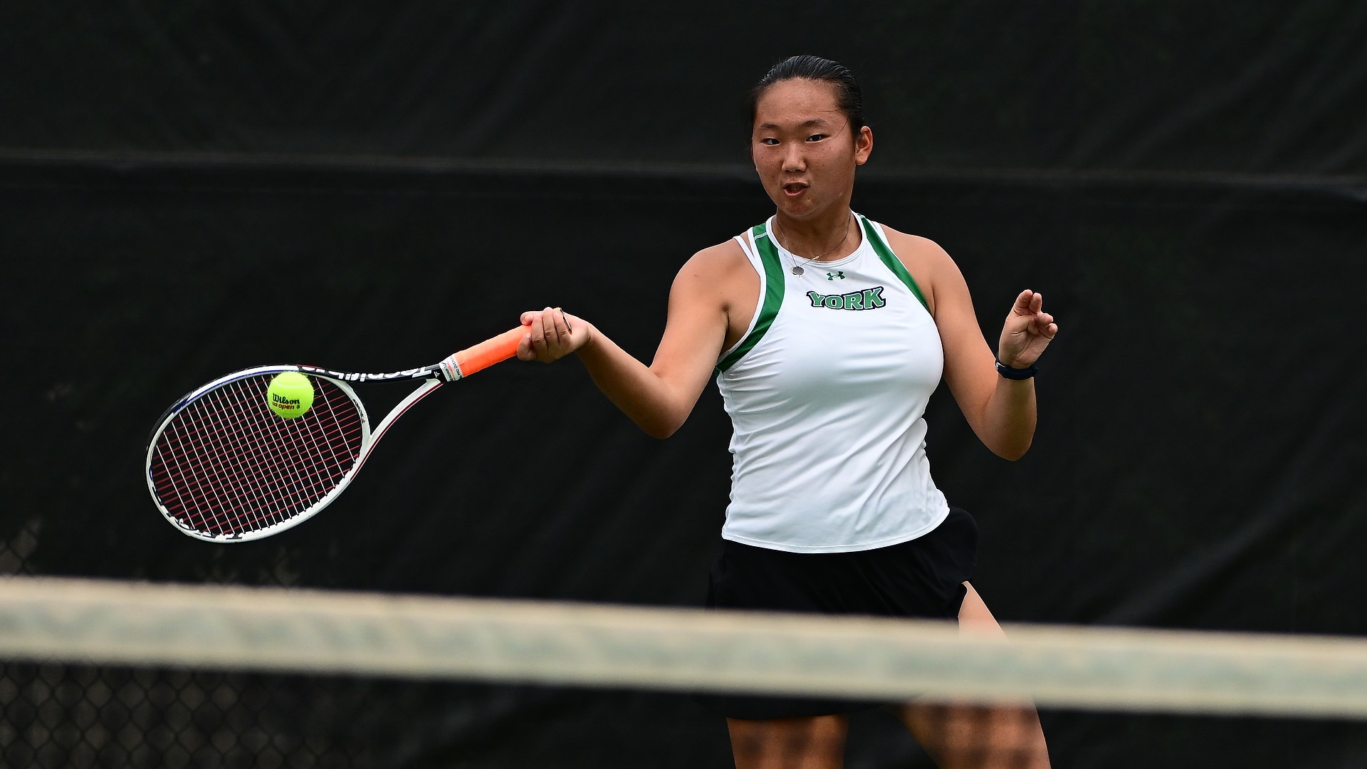 female tennis player hits ball