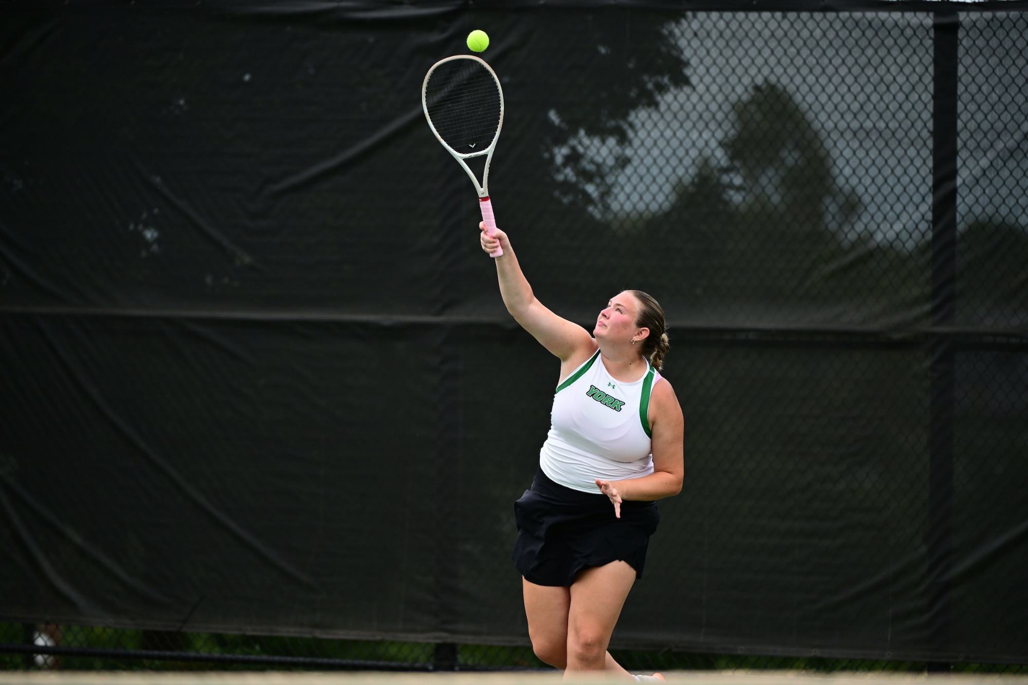 Female serving tennis ball