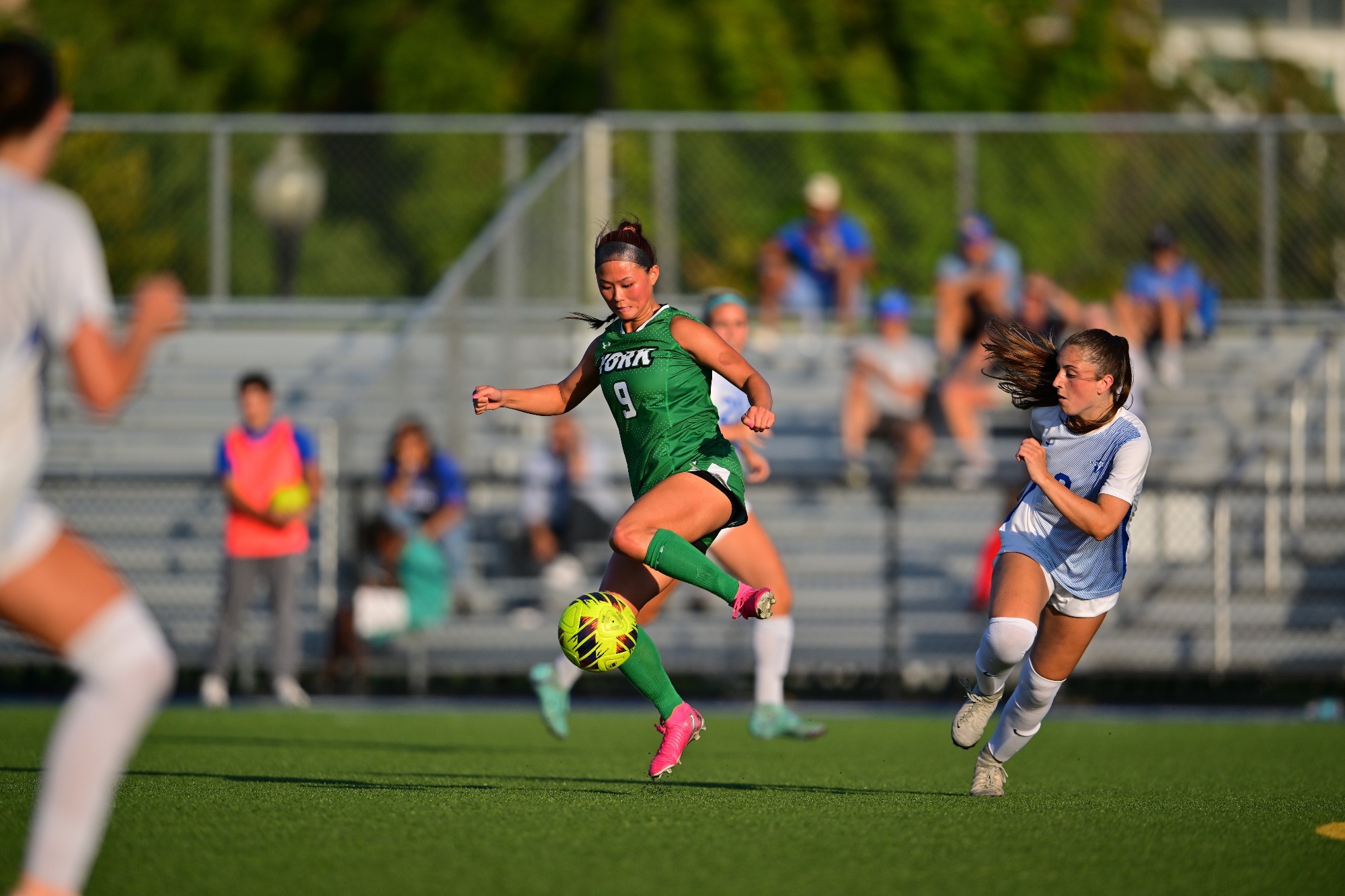 Female in green uniform controlling soccer ball