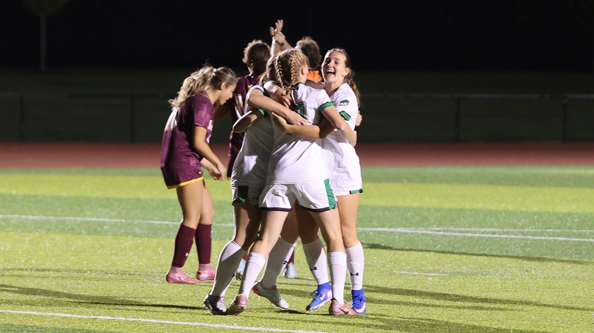 women soccer players celebrate a goal in a win over Salisbury