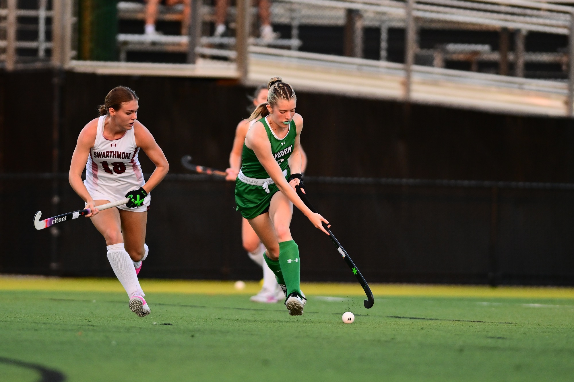 Female running with field hockey stick after ball