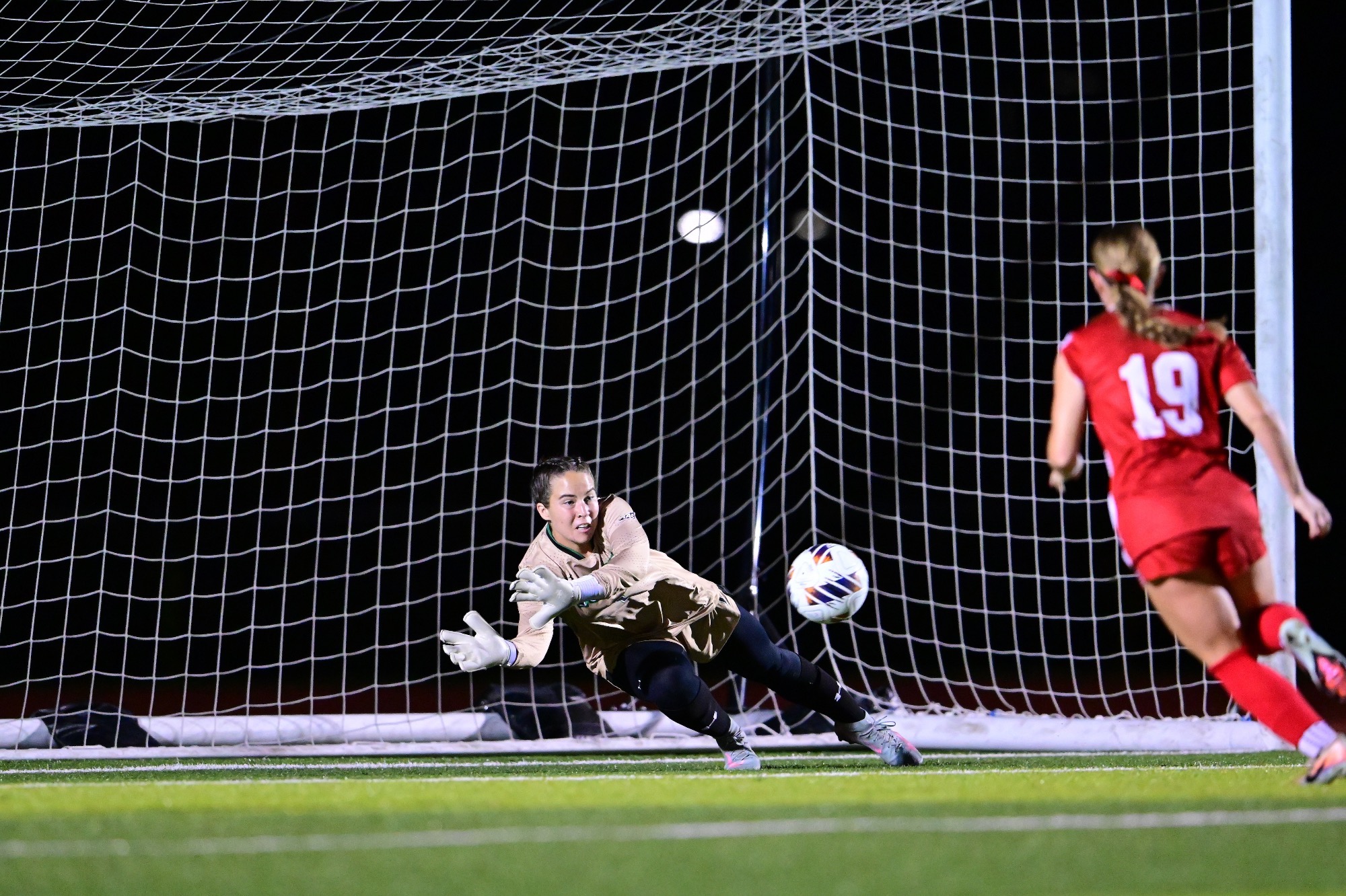 female goalkeeper diving to make a save in soccer