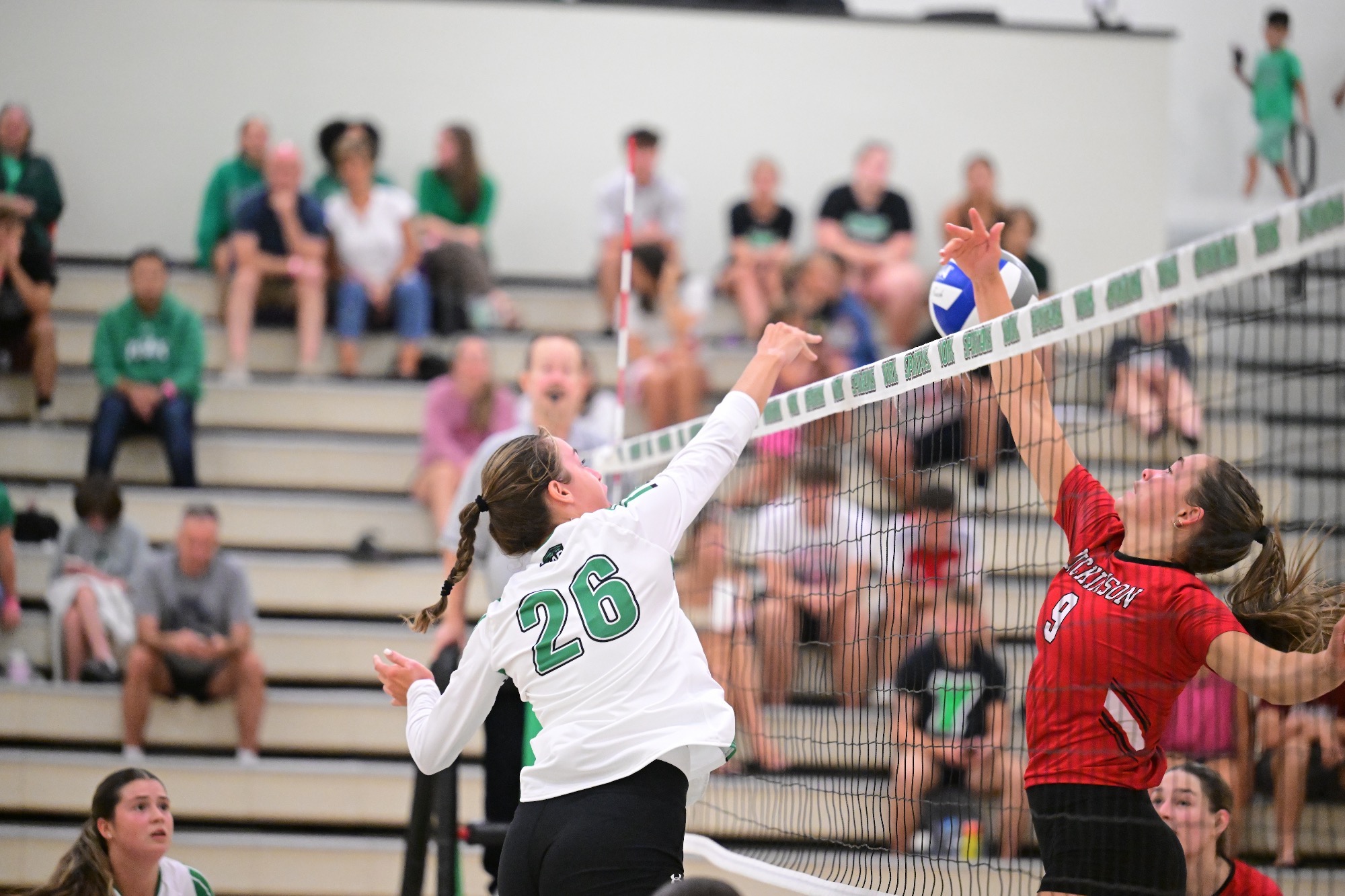 female striking volleyball near net