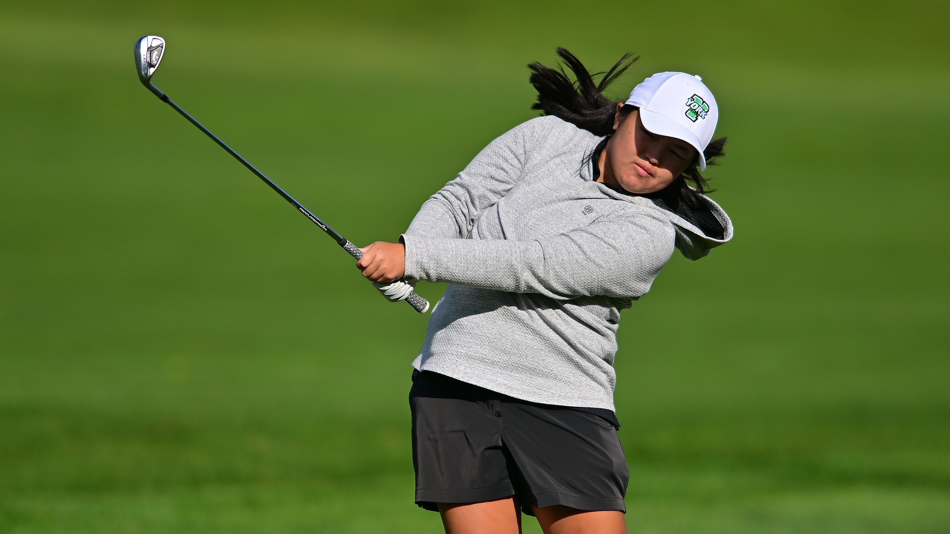 female golfer swings club