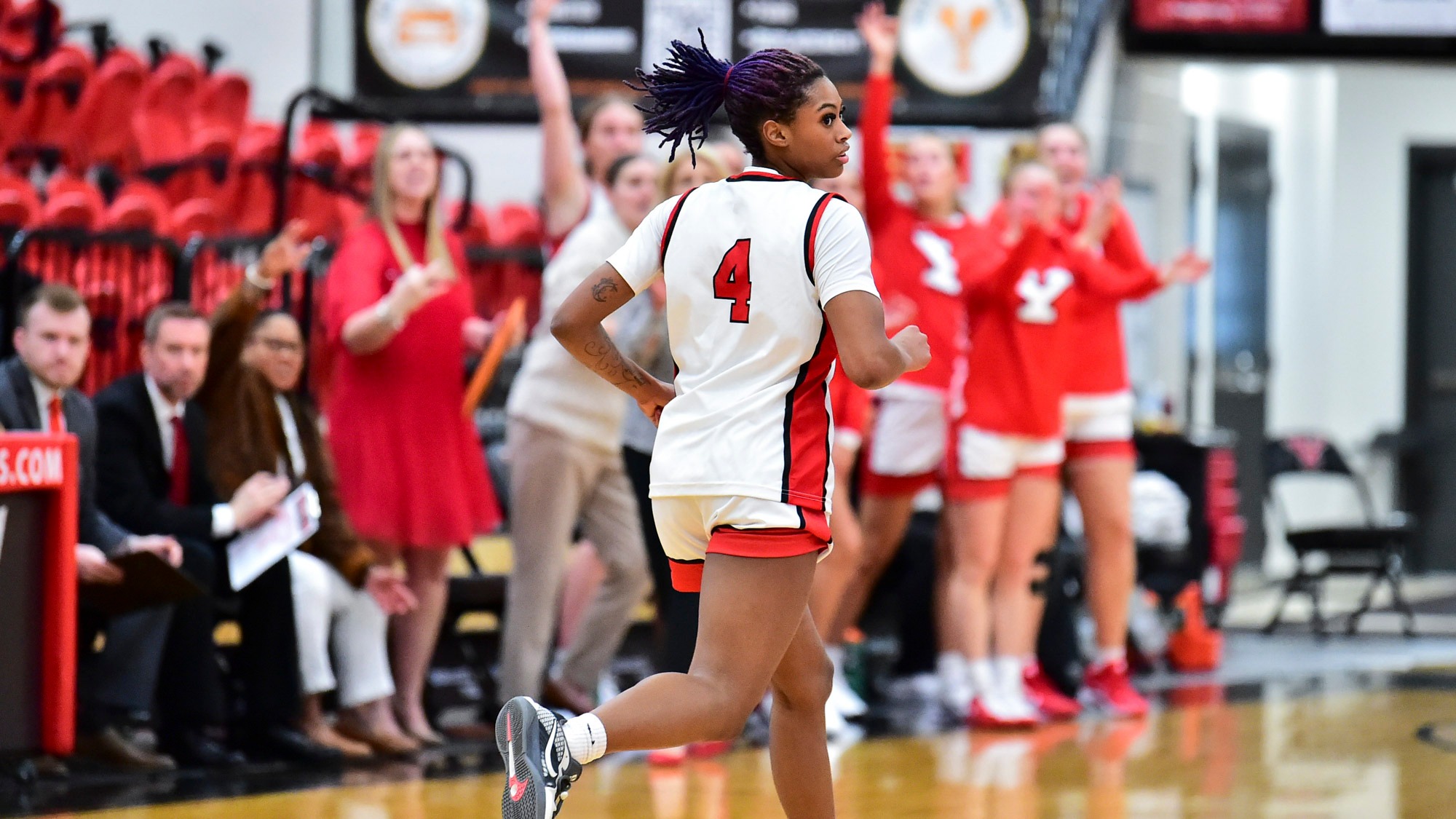 Youngstown State's Erica King runs back on defense after making a 3-pointer with YSU's bench celebrating in the background.
