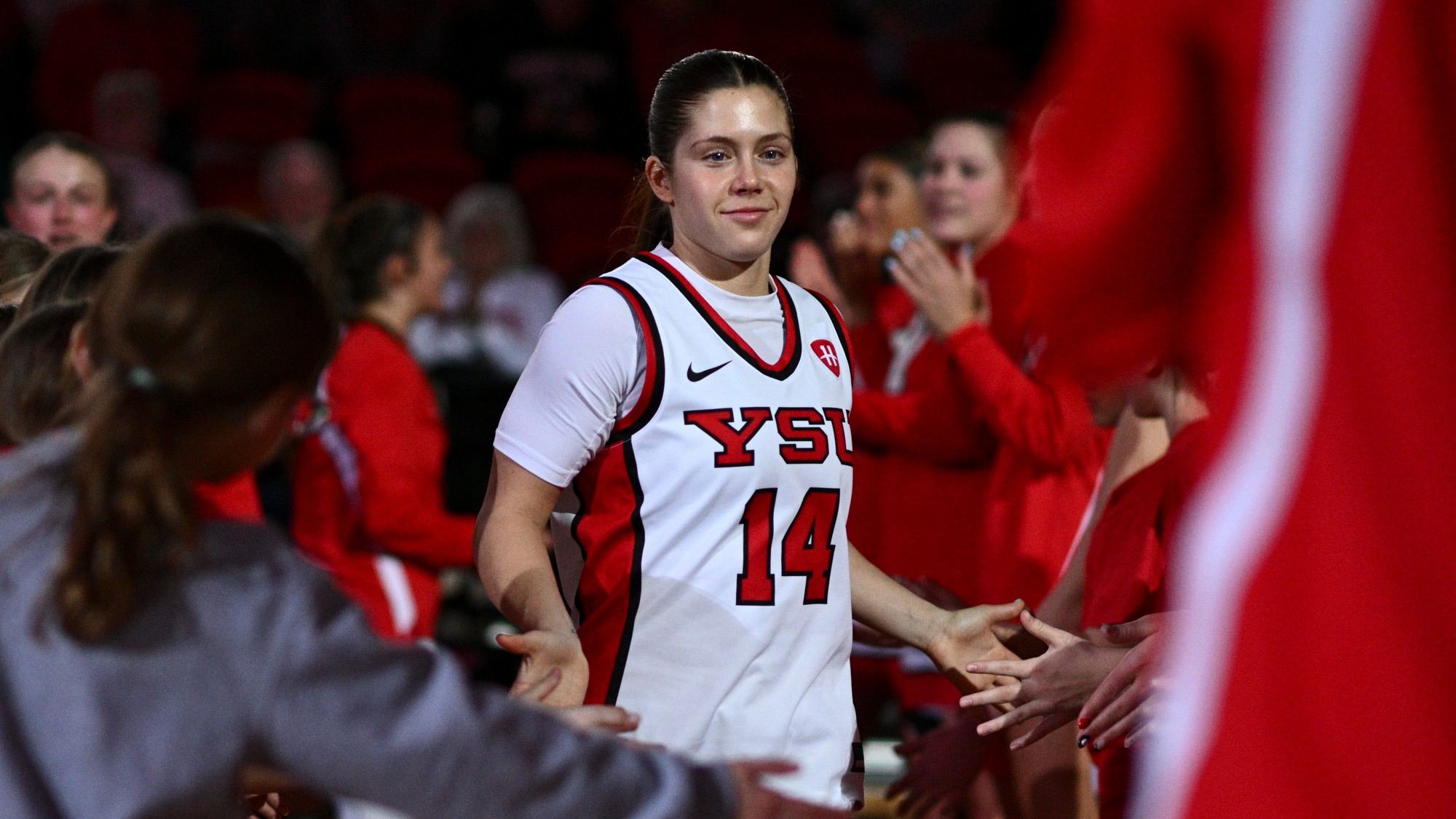 Casey Santoro high fives a youth girls group during starting lineup introductions.
