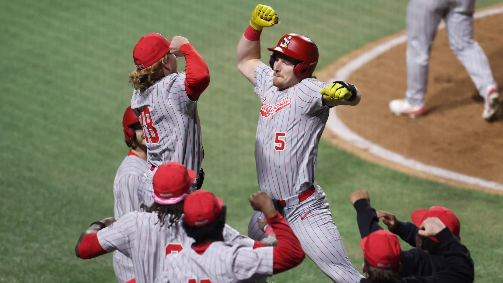 Brady Shannon leaps to high five and celebrate with teammates after hitting a home run during a YSU baseball game at Auburn on Feb. 13, 2026