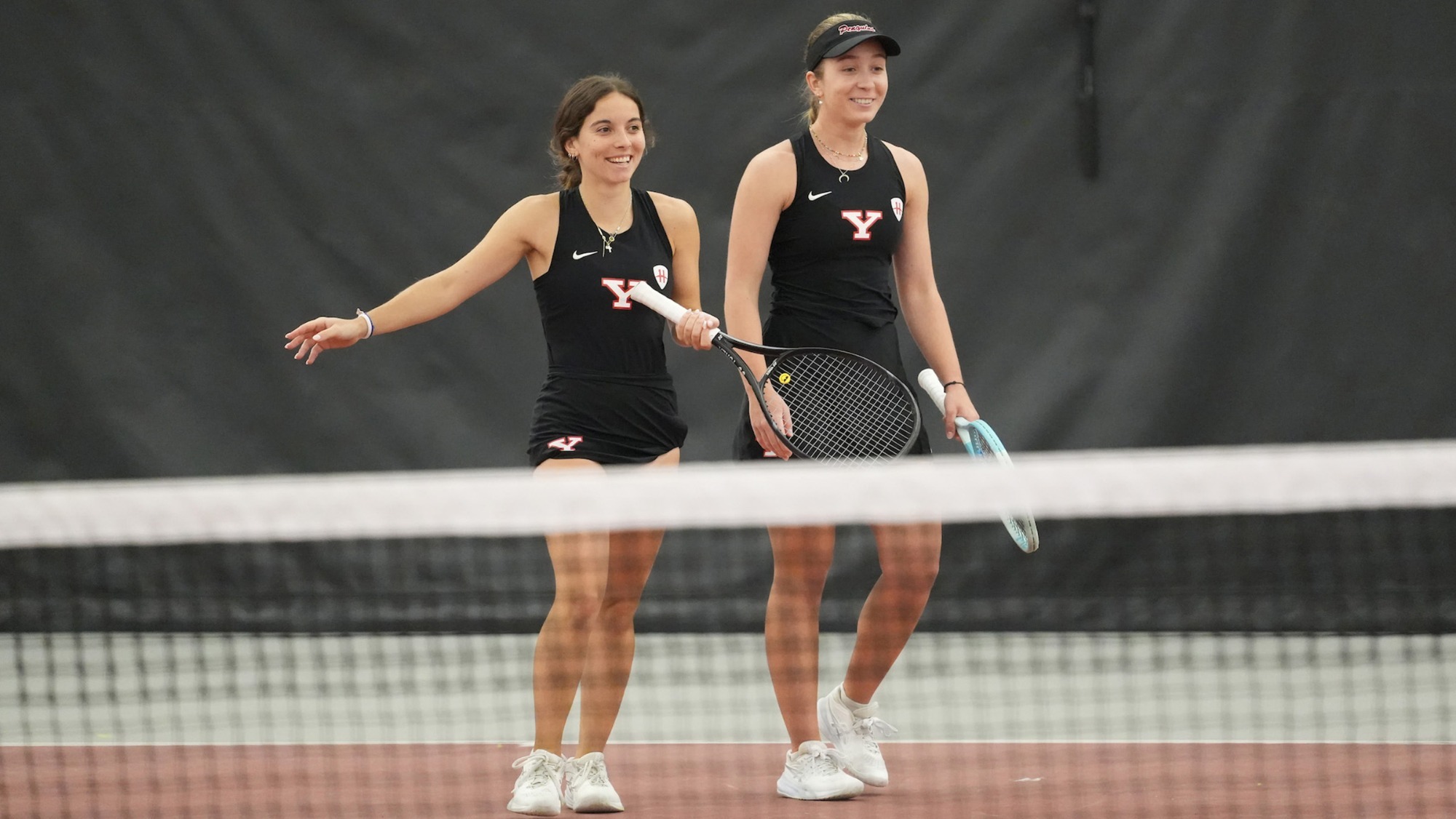 Yoana Dudova and Hanna Telzynska walk to the net after winning their doubles match