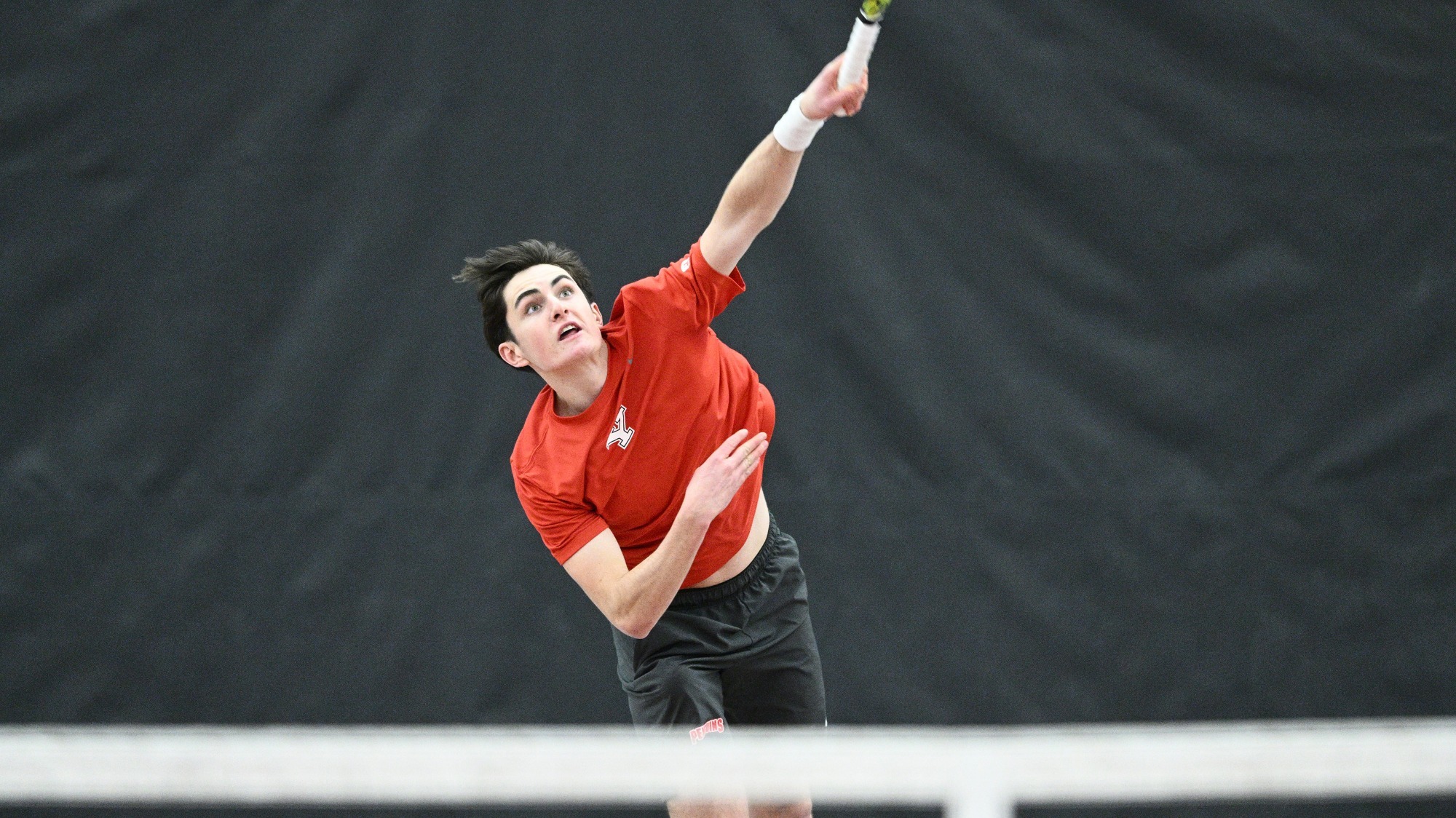 Oscar Gippet swings a tennis racquet