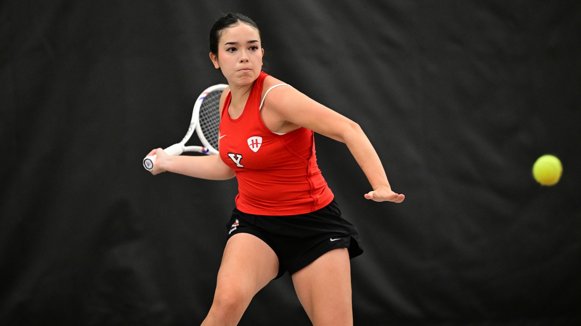 Sarah Partida Garcia swings her tennis racquet with the ball approaching
