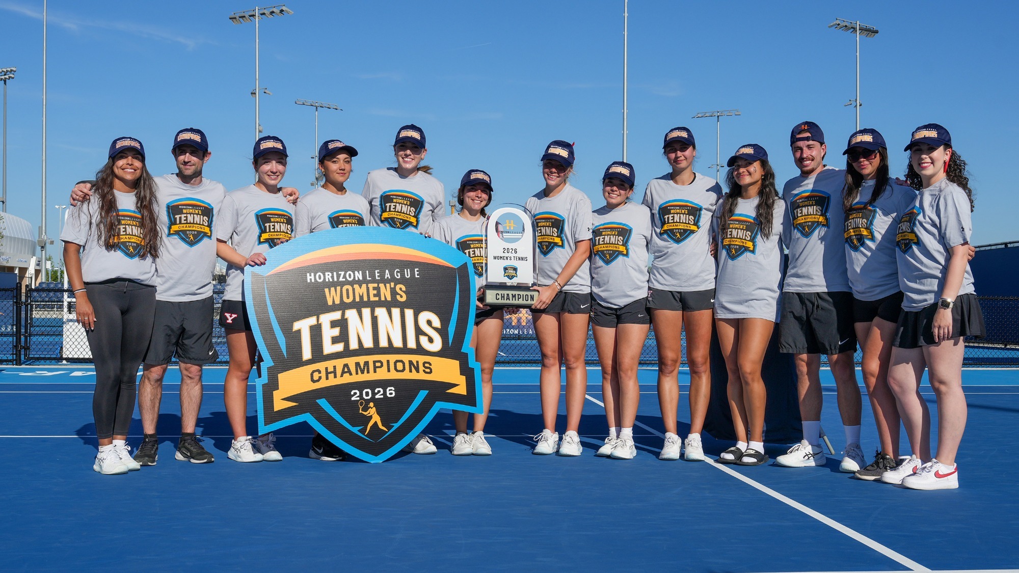 Horizon League Champions - YSU Women's Tennis pose with the trophy and badge