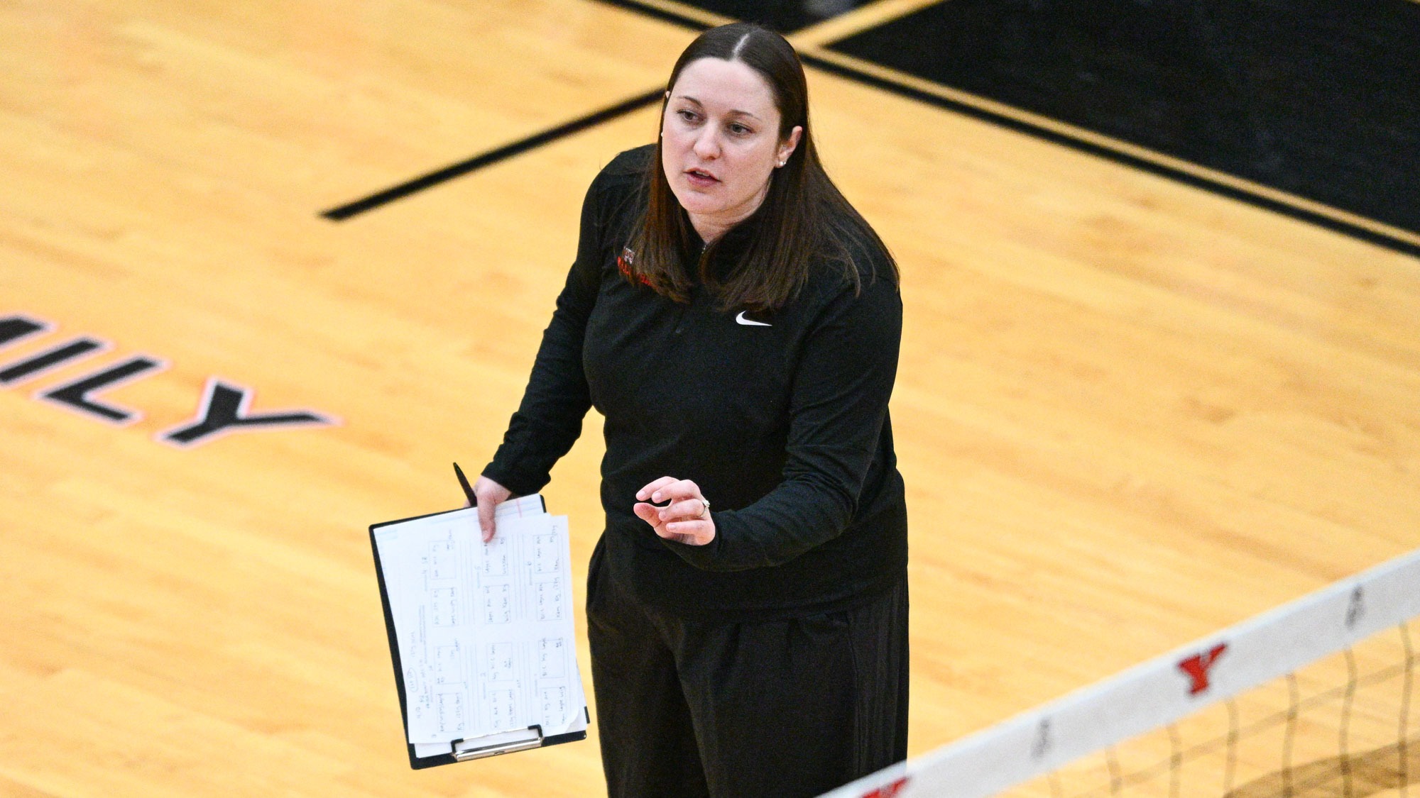 Riley Jarrett holds a clipboard and coaches from the sideline at the Youngstown State volleyball team's exhibition match vs. Fairmont State on April 10, 20206, inside Zidian Family Arena at Beeghly Center. Photo by Robert Hayes.