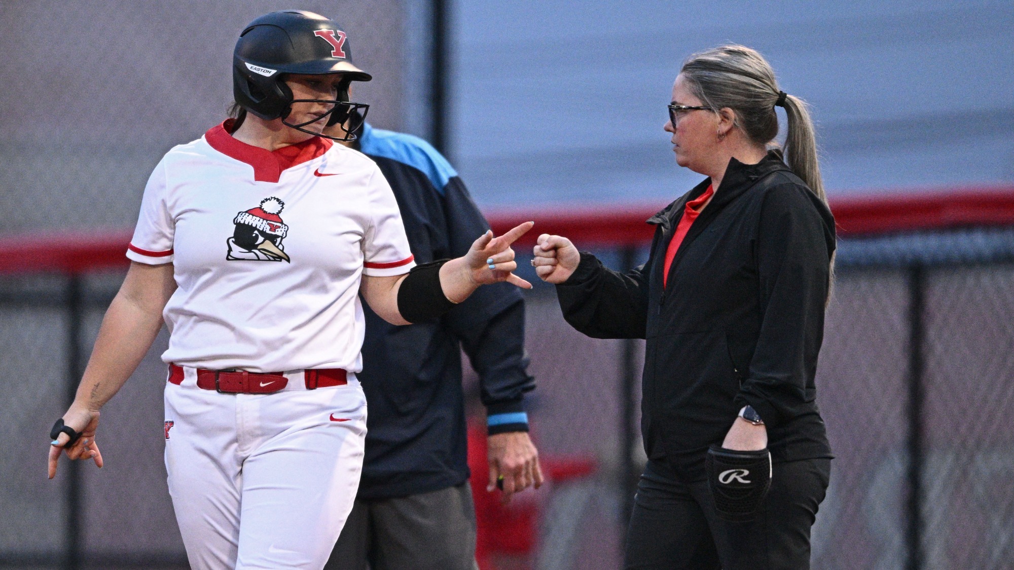 YSU Head Coach Erin Pond congratulates Emma Gilkerson at first base