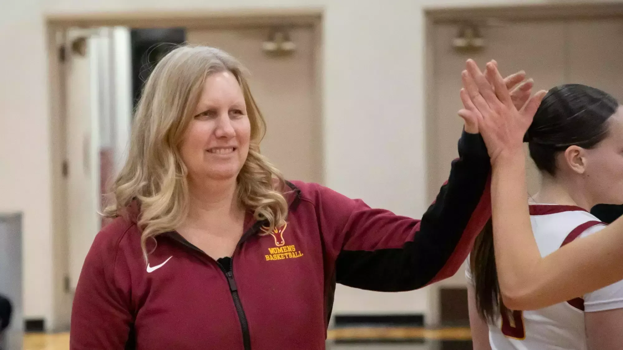 Coach Lanette Hooper high fives one of her players