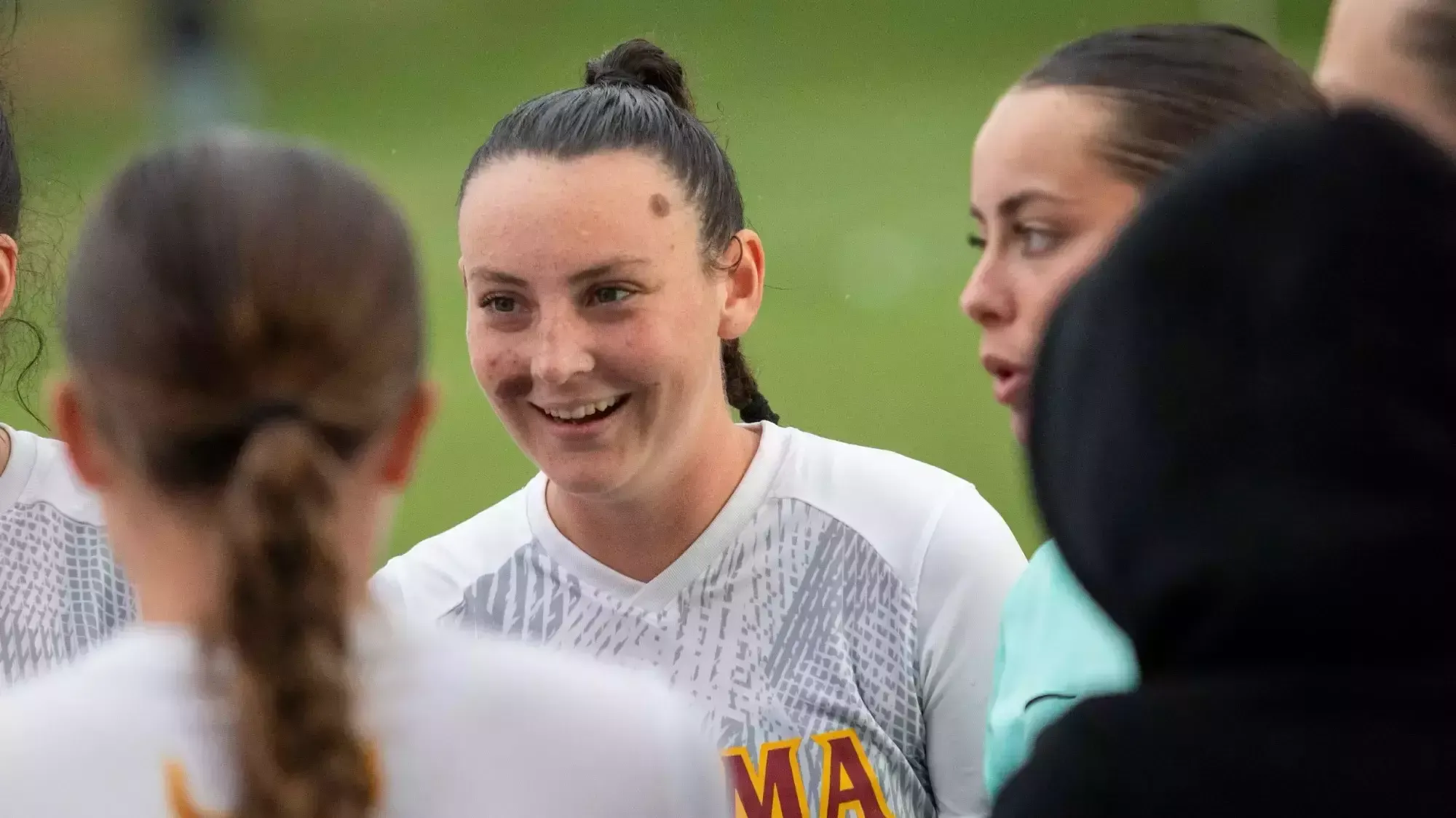 India Wiemers smiles with team