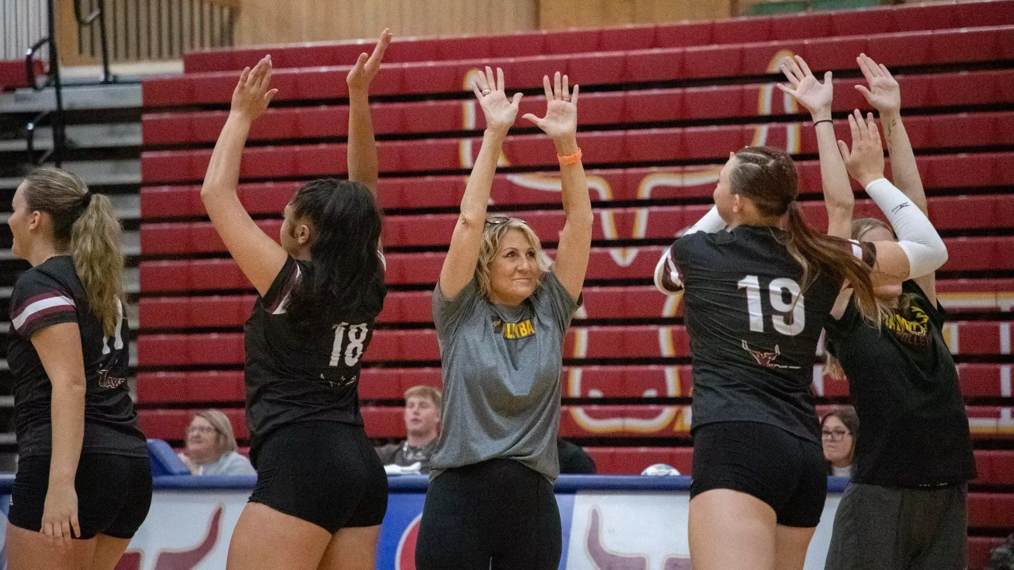 Coach Darci Dekker high-fives team before the game
