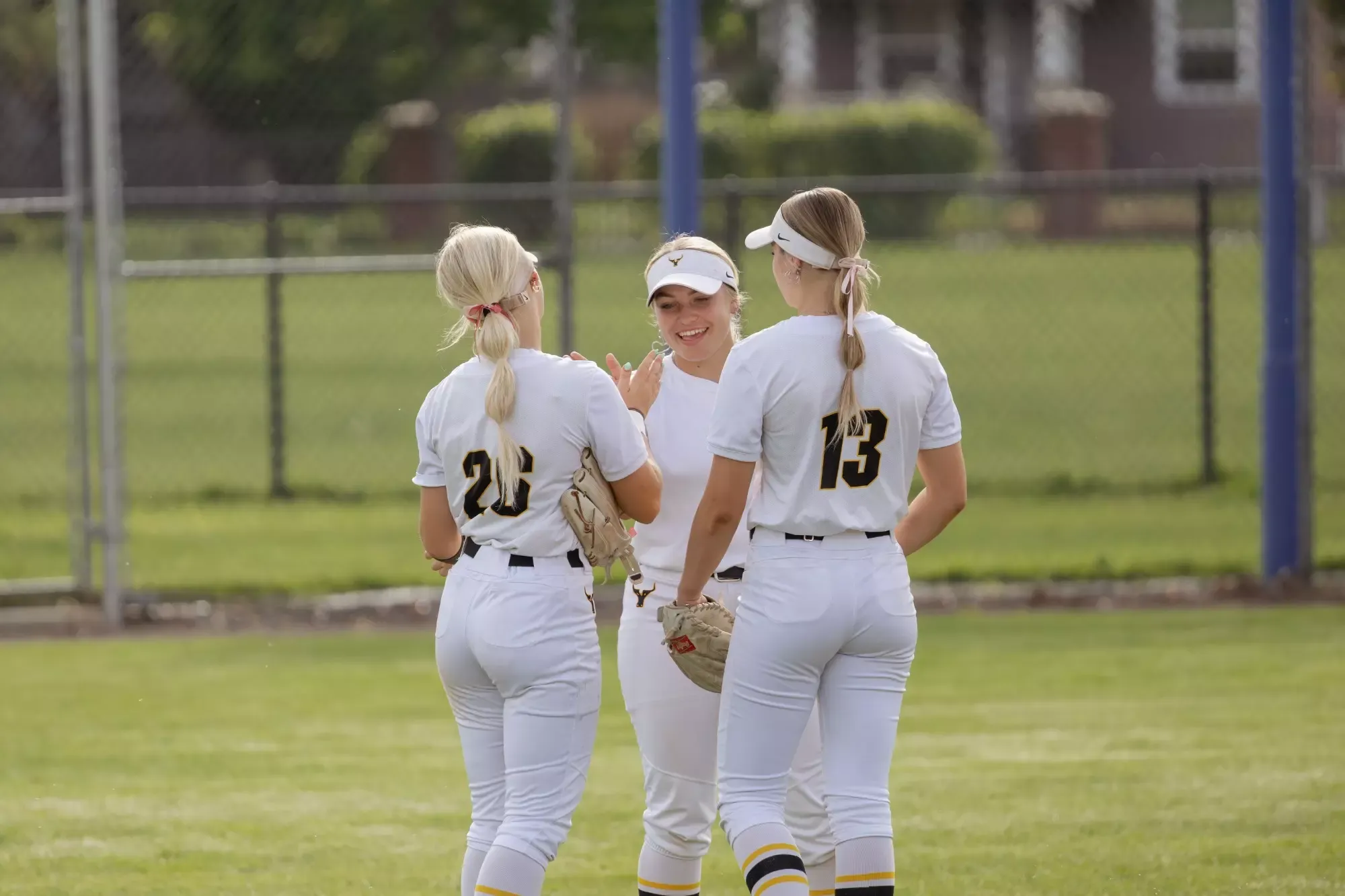 Cheyenne Justice, Kylee Bradley and Rillee Huber celebrate in the outfield